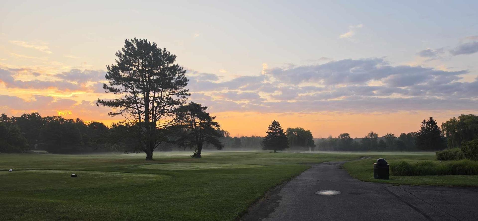 Dusk settling over a green, mist rising off the fairway